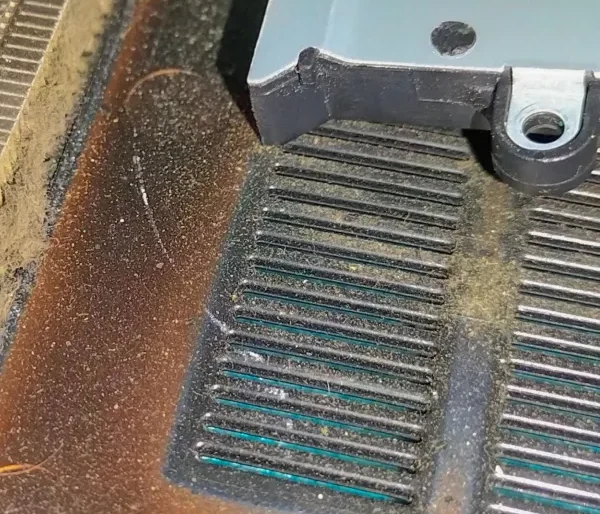 Laptop ventilation grills covered with dust buildup, indicating overheating risk and the need for professional internal cleaning.